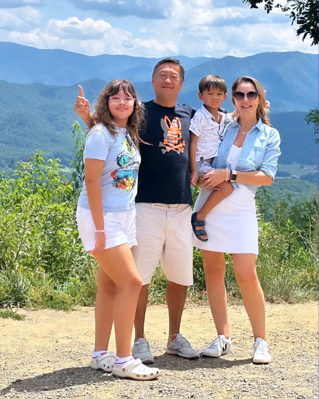 Andreia Marchetto with her family outdoors, a mountain valley behind them.