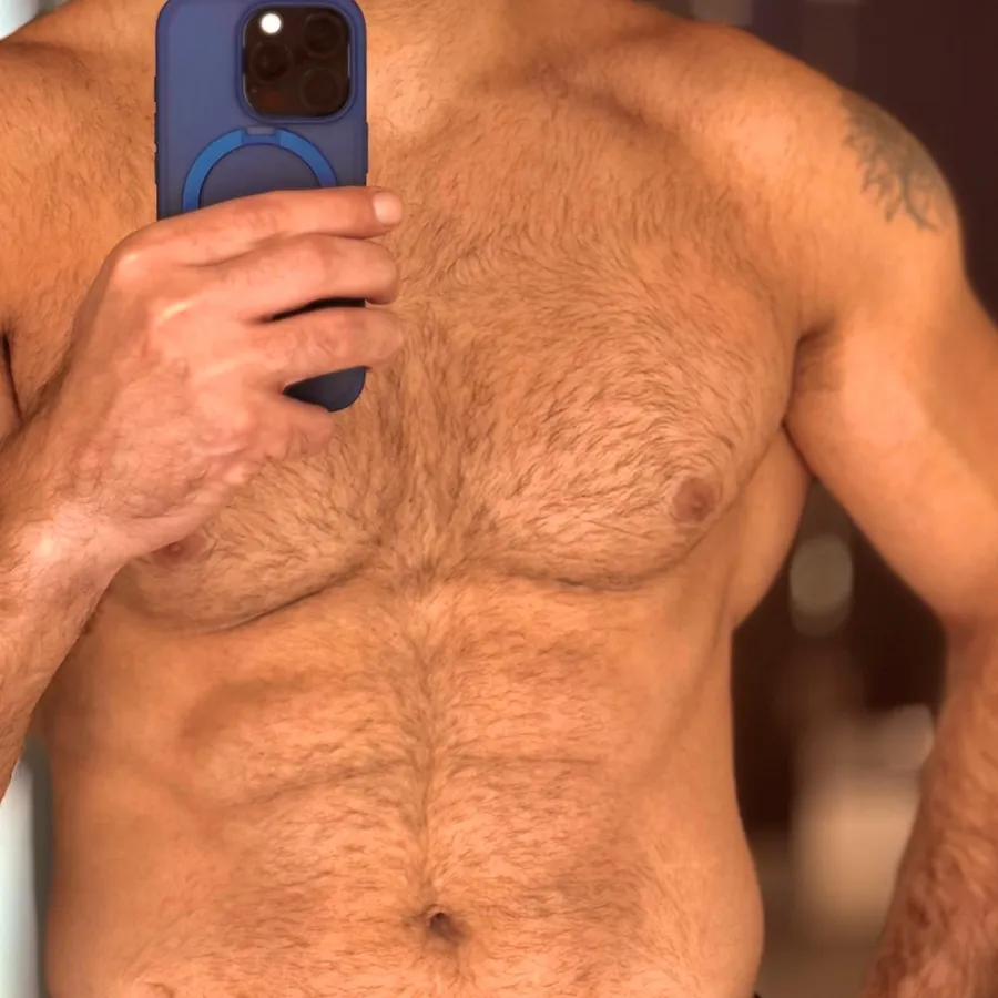 Close crop of a man’s chest and abdomen in a mirror, photographed before the sessions.